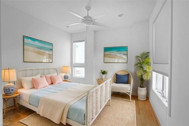 bedroom with multiple windows, ceiling fan, and light wood finished floors