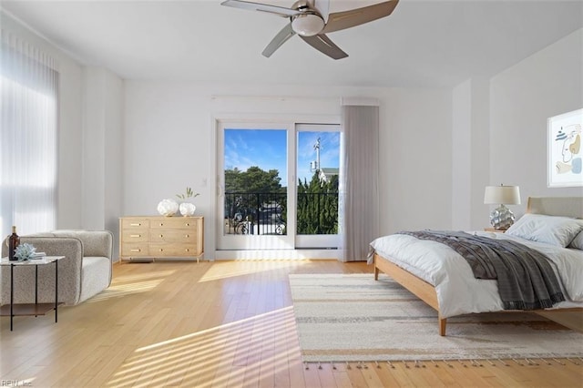 bedroom featuring a ceiling fan, light wood-style flooring, and access to exterior