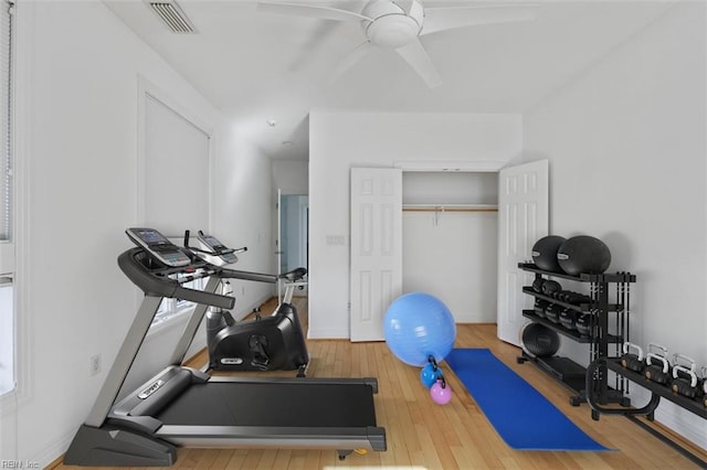 exercise room with a ceiling fan, wood-type flooring, and visible vents