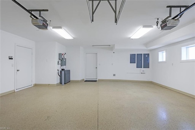 garage with baseboards, electric panel, and a garage door opener