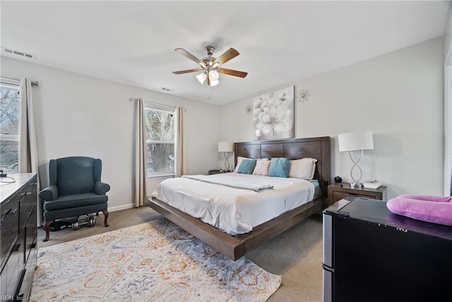 carpeted bedroom featuring ceiling fan, visible vents, and baseboards