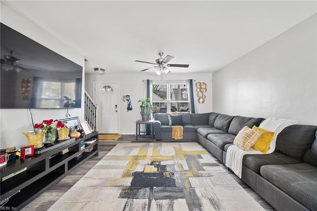 living area featuring stairway, wood finished floors, and a ceiling fan