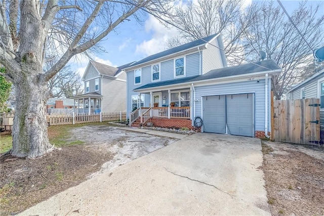 traditional-style home featuring a garage, driveway, fence, and a porch