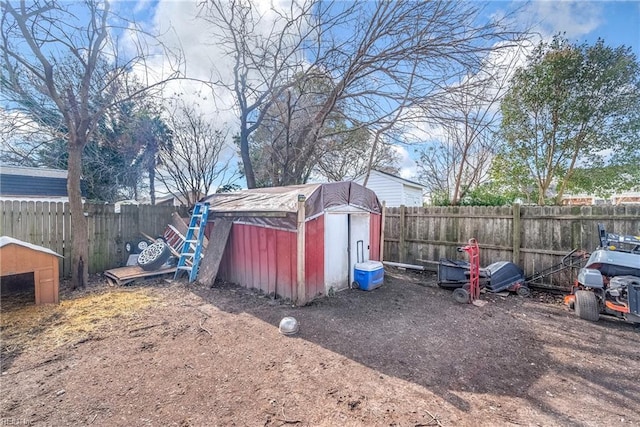 view of yard with a storage shed, a fenced backyard, and an outdoor structure