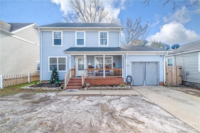 traditional-style home with an attached garage, driveway, fence, and a porch