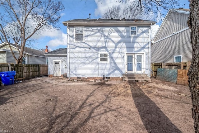 rear view of house with crawl space and fence