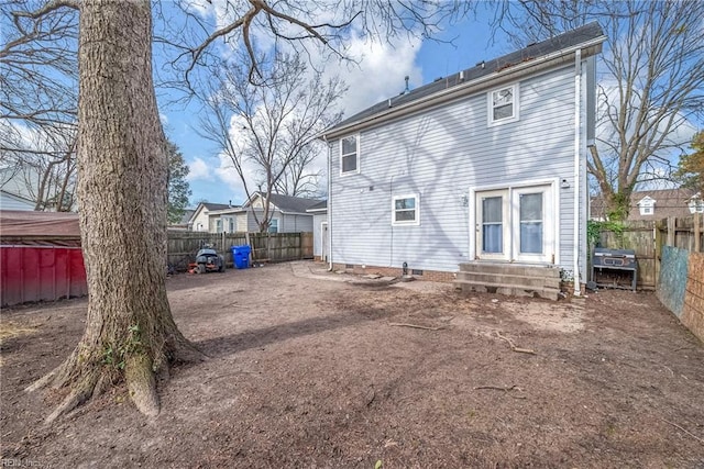 back of house with entry steps, crawl space, and a fenced backyard