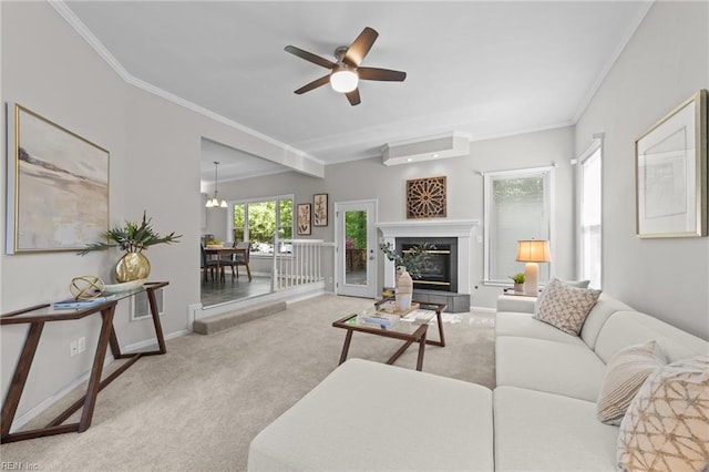 carpeted living area featuring a wall mounted AC, baseboards, crown molding, and a glass covered fireplace