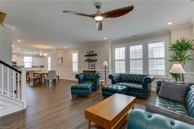 living room with a wainscoted wall, dark wood-type flooring, crown molding, and a decorative wall