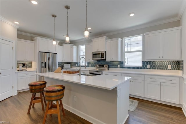 kitchen with white cabinetry, a center island with sink, appliances with stainless steel finishes, and a sink