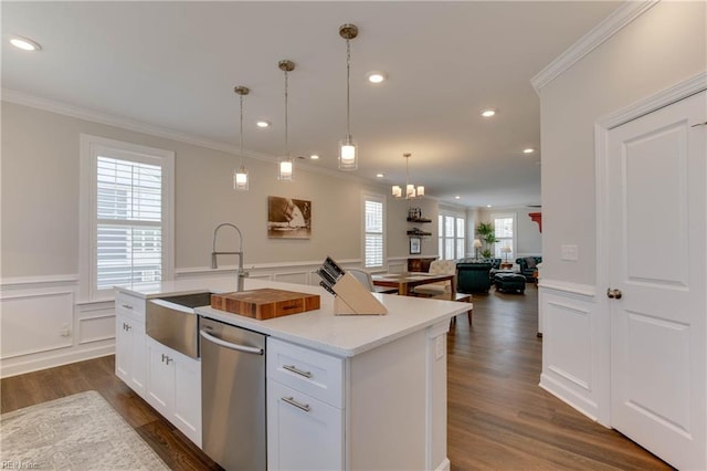 kitchen with a sink, light countertops, stainless steel dishwasher, wainscoting, and crown molding