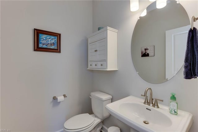 half bathroom featuring toilet and a sink