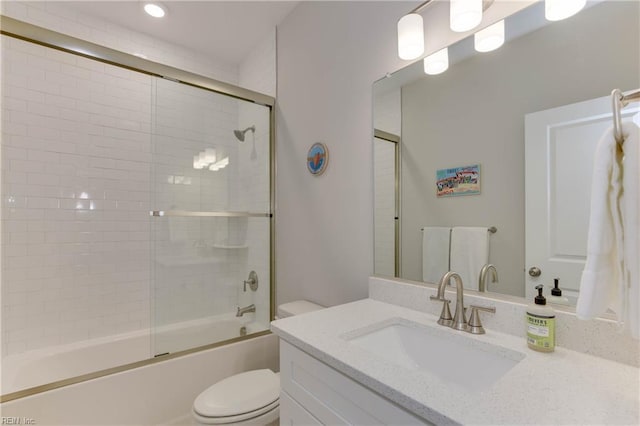 full bathroom featuring vanity, toilet, and bath / shower combo with glass door