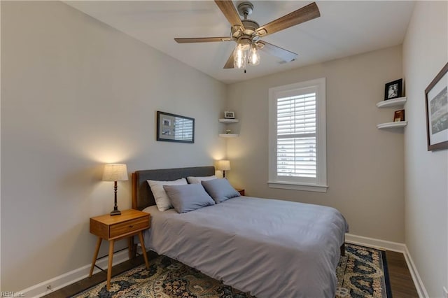 bedroom featuring wood finished floors, a ceiling fan, and baseboards