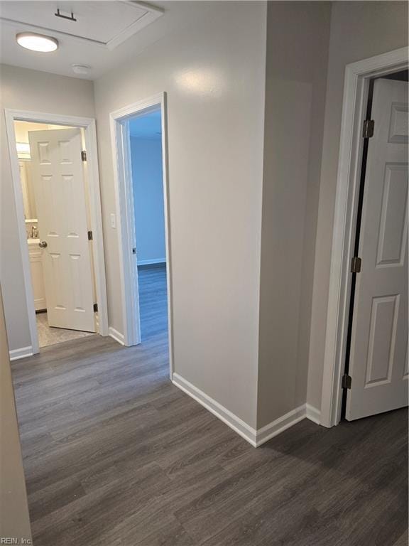 hall with dark wood-style floors and baseboards