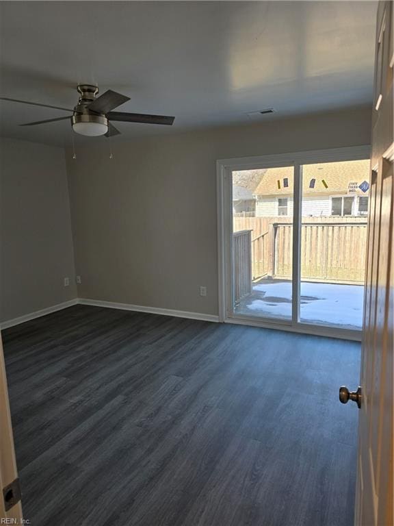 empty room featuring dark wood-style floors, ceiling fan, and baseboards