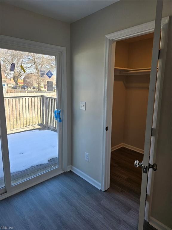 doorway with dark wood-style floors and baseboards