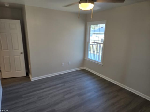 empty room featuring ceiling fan, dark wood-type flooring, and baseboards