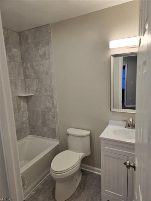 bathroom featuring toilet, baseboards, and vanity