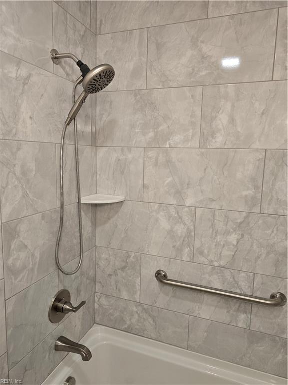 interior details featuring shower / washtub combination