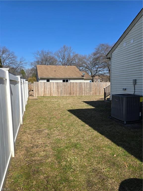 view of yard with central AC and a fenced backyard