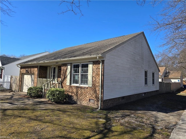 view of front of property with a garage, crawl space, brick siding, and fence