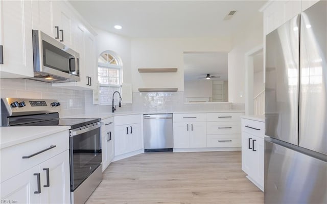 kitchen featuring open shelves, tasteful backsplash, white cabinets, and stainless steel appliances