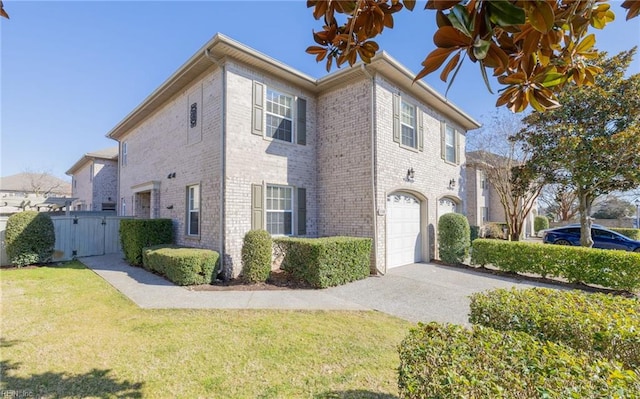 view of front of house with a garage, driveway, brick siding, a gate, and a front yard