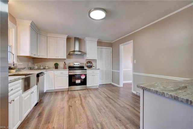 kitchen with light stone counters, light wood finished floors, stainless steel appliances, white cabinets, and wall chimney range hood