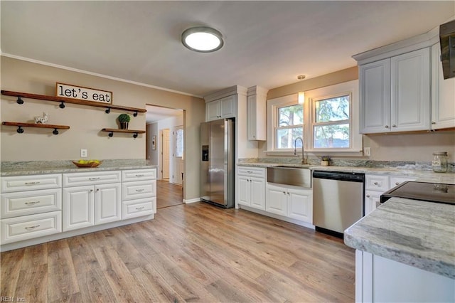 kitchen featuring light wood finished floors, appliances with stainless steel finishes, open shelves, and a sink