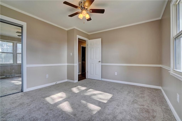 empty room featuring ceiling fan, carpet floors, ornamental molding, and baseboards