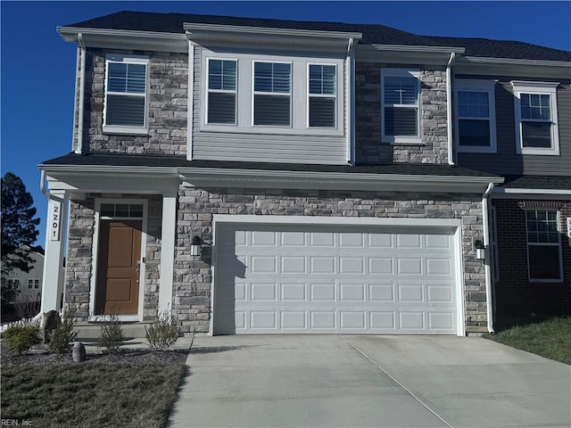 view of front of property featuring concrete driveway, stone siding, and an attached garage