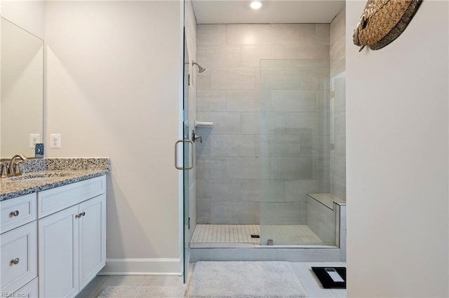 bathroom featuring a shower stall, vanity, and baseboards