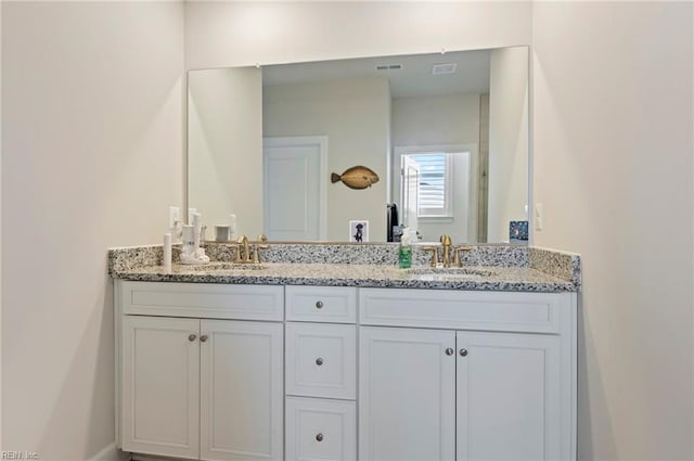 full bathroom with double vanity, visible vents, and a sink