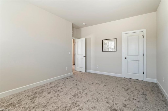 carpeted spare room featuring baseboards