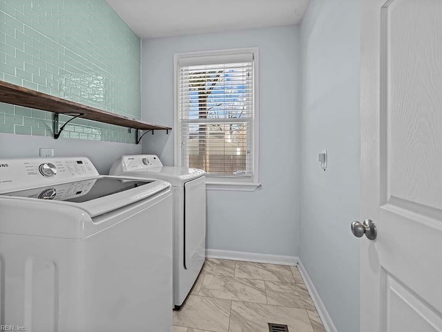 laundry room featuring laundry area, baseboards, marble finish floor, and independent washer and dryer