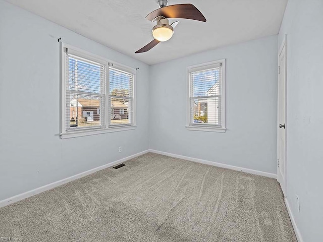 spare room with carpet floors, baseboards, and a ceiling fan