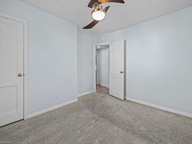 unfurnished bedroom with ceiling fan, carpet floors, and baseboards