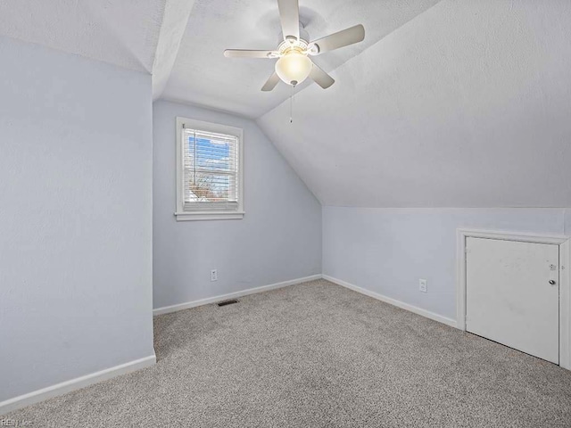 bonus room featuring vaulted ceiling, a textured ceiling, carpet, and visible vents