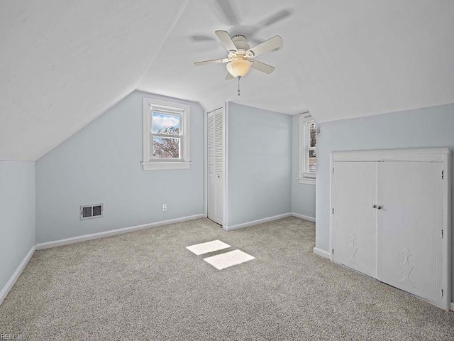 additional living space with carpet, visible vents, vaulted ceiling, ceiling fan, and baseboards