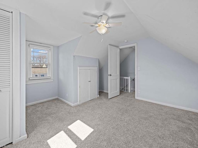 additional living space featuring lofted ceiling, a ceiling fan, baseboards, and carpet flooring