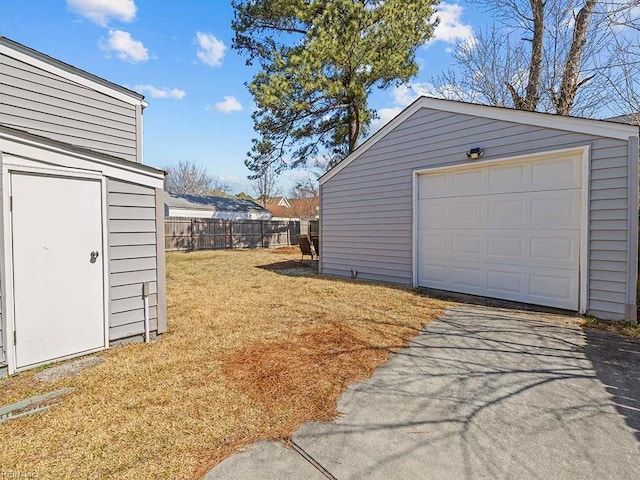 detached garage with fence and driveway