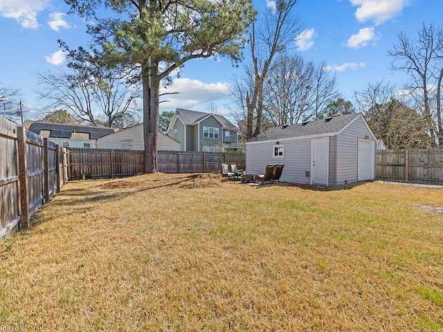 view of yard featuring a garage, an outbuilding, and a fenced backyard