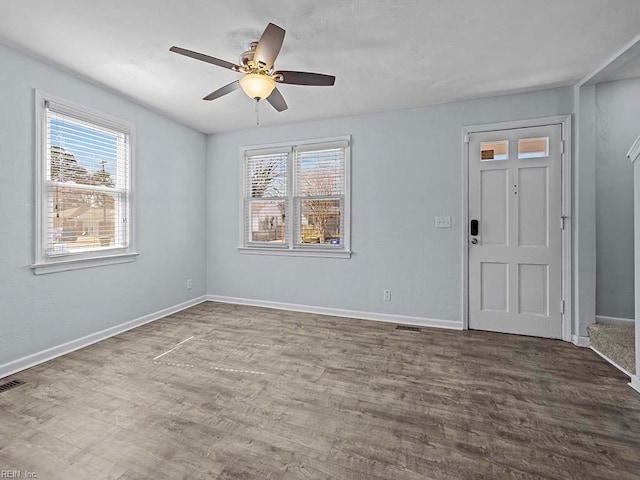 interior space with a wealth of natural light, baseboards, and wood finished floors