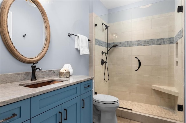 bathroom with toilet, a shower stall, and vanity