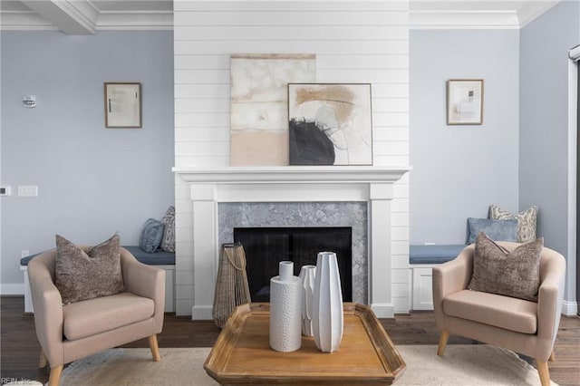 living area with baseboards, ornamental molding, wood finished floors, and a high end fireplace