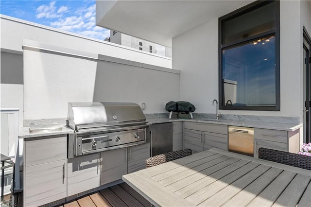 view of patio with a sink, outdoor dining area, an outdoor kitchen, and a grill