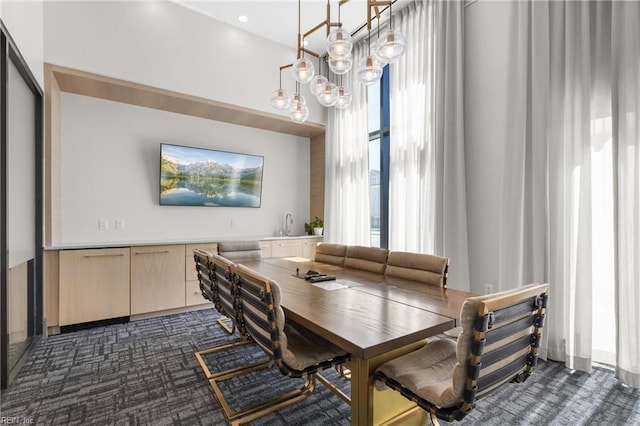 dining area with a chandelier and dark carpet