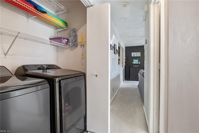 washroom with washer and dryer, laundry area, and light colored carpet