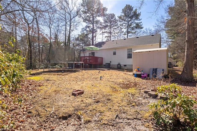 view of yard featuring a trampoline and a deck